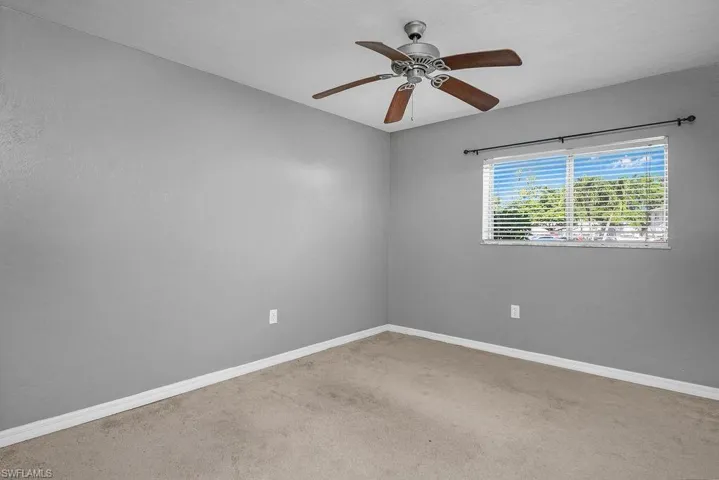 Spare room featuring ceiling fan and light colored carpet
