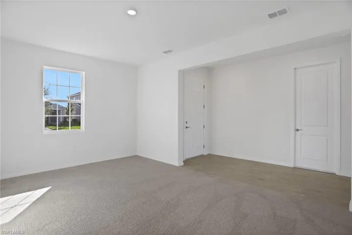 Spare room featuring light colored carpet and baseboards