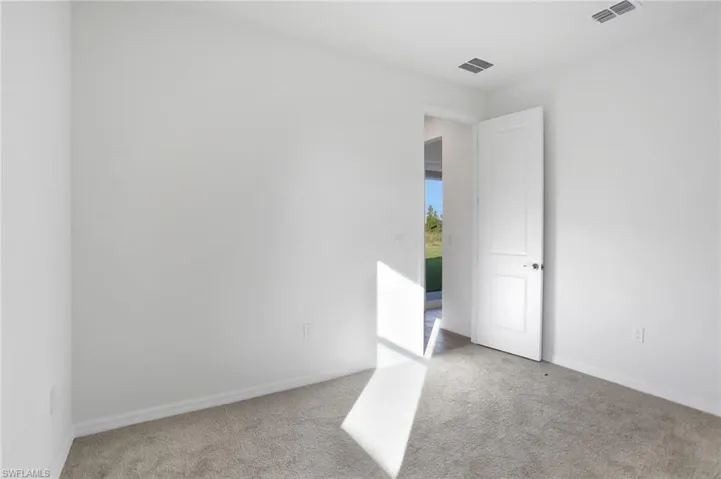 Empty room with light carpet and baseboards