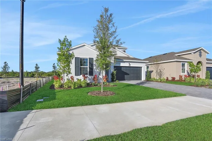 View of front of house with driveway, stucco siding, and a garage
