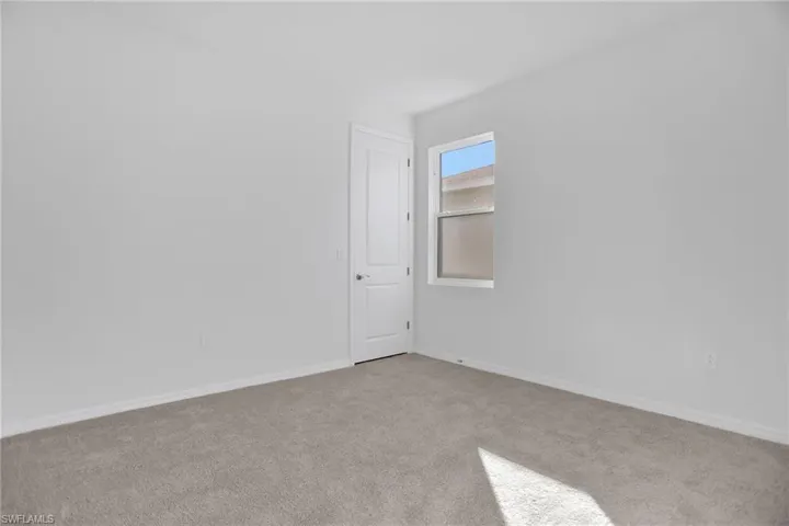 Empty room featuring carpet flooring and baseboards