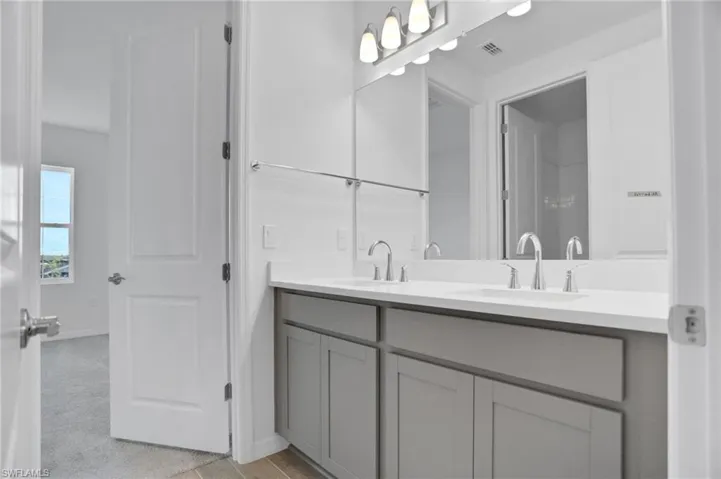 Full bath with double vanity and baseboards