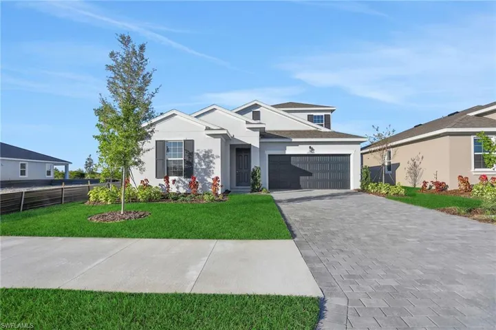 View of front of property with decorative driveway and stucco siding