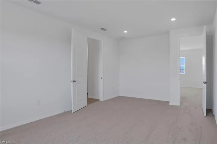 Spare room featuring light carpet and recessed lighting