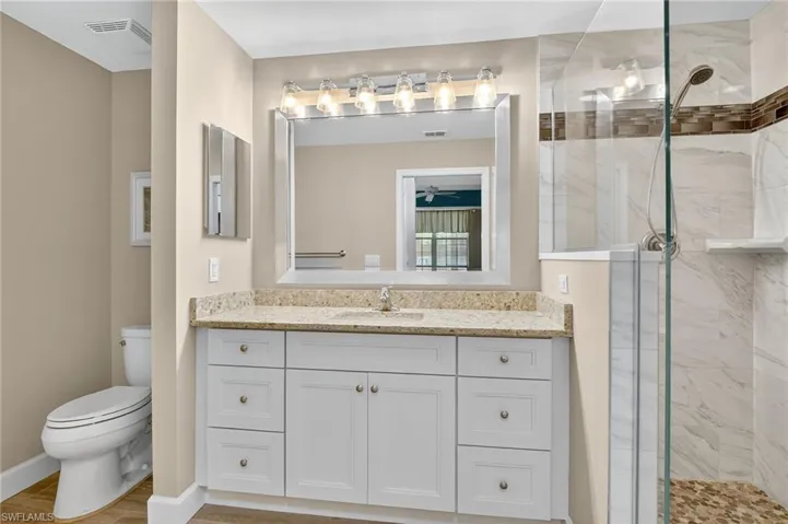 Full bathroom featuring vanity and a marble finish shower