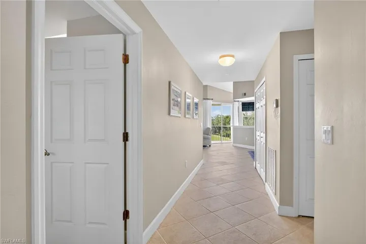 Corridor with light tile patterned floors and baseboards