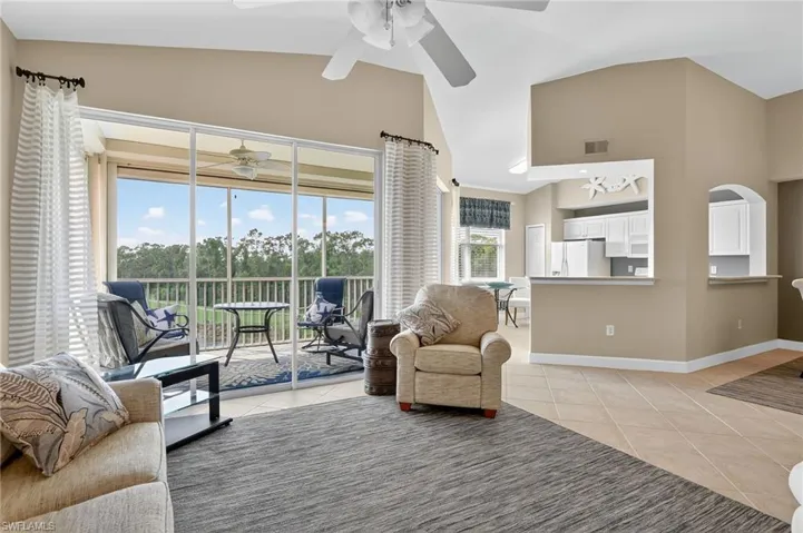 Living room with light tile patterned floors and high vaulted ceiling