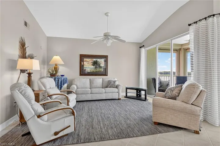 Tiled living room with vaulted ceiling and ceiling fan