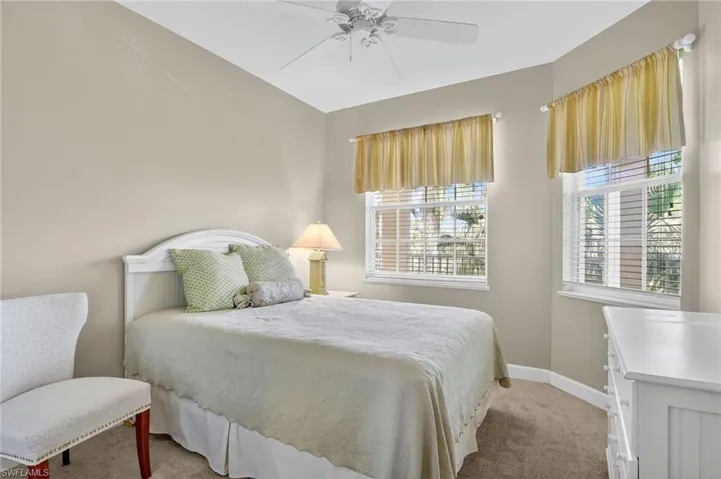 Carpeted bedroom with baseboards and a ceiling fan