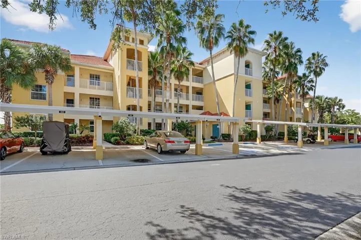 View of apartment building / complex with covered parking