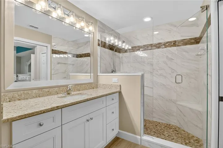 Full bathroom featuring a stall shower and vanity