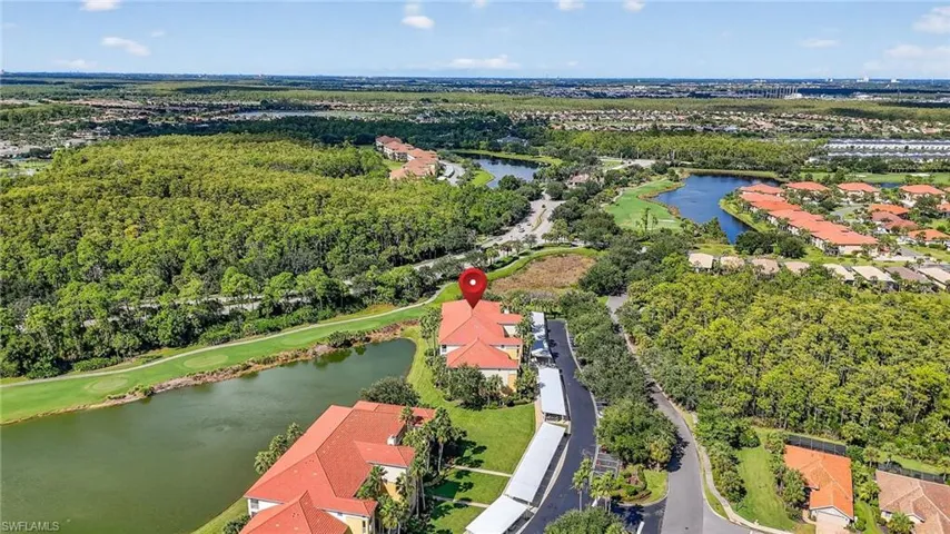 Aerial perspective of suburban area with a large body of water and a golf course