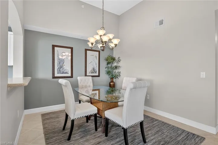 Dining space featuring light tile patterned flooring and a chandelier