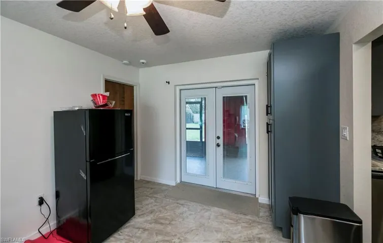 featuring Dining ceiling fan, refrigerator, a textured ceiling, and french doors