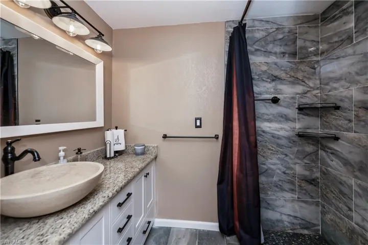 Bathroom with a shower with shower curtain, hardwood / wood-style flooring, and vanity