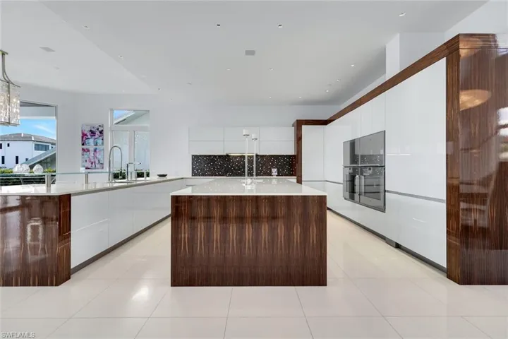 Allmilmo kitchen with book-matched Macassar wood, Miele and Gaggenau appliances, and Thassos marble floors.