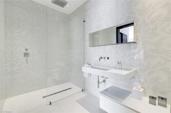 Full bath featuring tile walls, walk in shower, and tile patterned floors