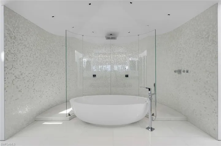 Spa-style bathroom with Bisazza mosaic tile, Dornbracht fixtures, Thassos marble floors, and glass shower.