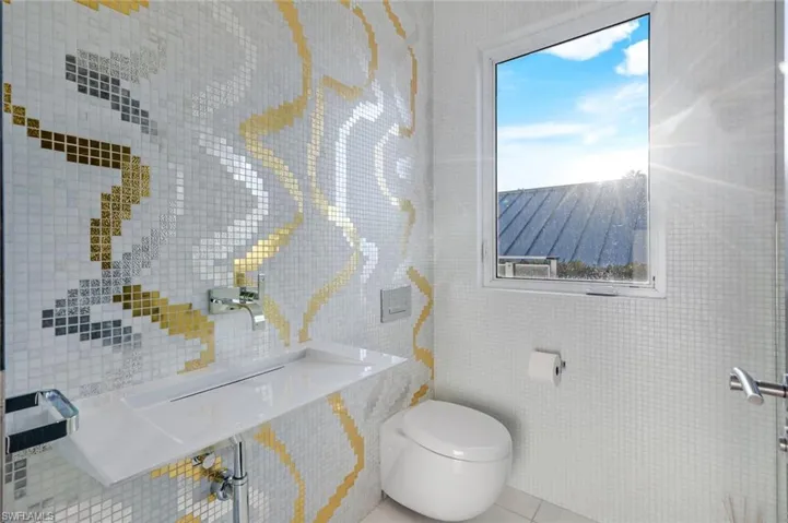 Elegant half bath with Bisazza gold leaf mosaic tile and premium Dornbracht fixtures