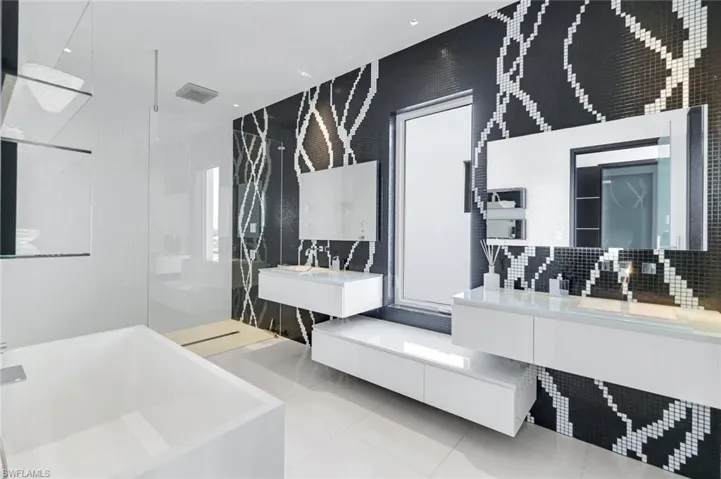 Full bath featuring a bathtub, a walk in shower, light tile patterned floors, two vanities, and pet washing area