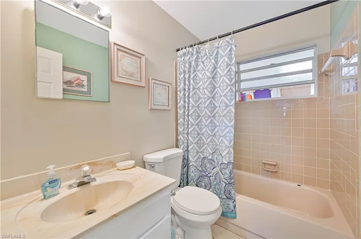 Full bathroom with vanity, toilet, and shower / bath combo with shower curtain