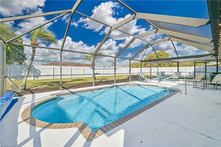 View of pool with a patio and glass enclosure