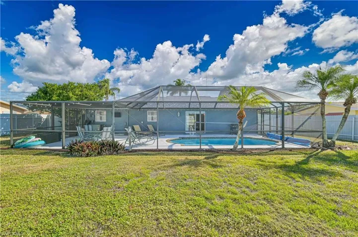 Back of property featuring a fenced in pool, a lanai, a lawn, and a patio