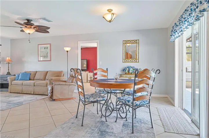 Dining space with light tile patterned floors and ceiling fan