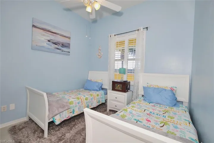Bedroom featuring dark carpet and a ceiling fan