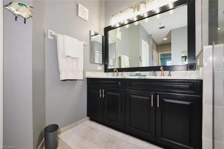 Full bath with double vanity and light tile patterned flooring