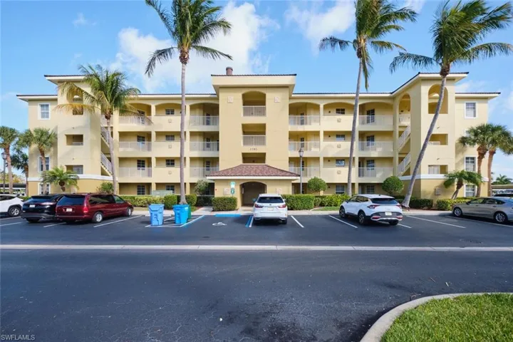 View of apartment building / complex featuring uncovered parking