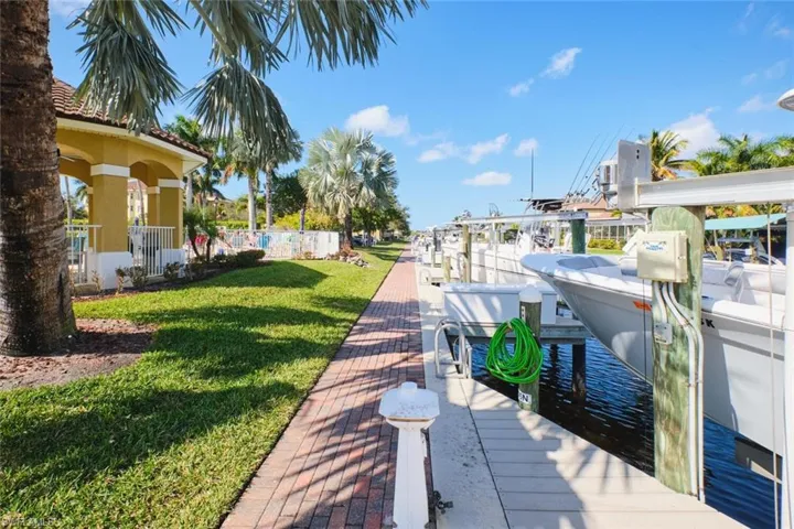Dock area with a water view, a yard, and boat lift