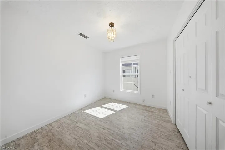 Unfurnished bedroom with hanging lights, a closet, and a textured ceiling