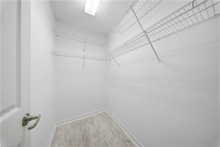 Walk in closet with light wood finished floors
