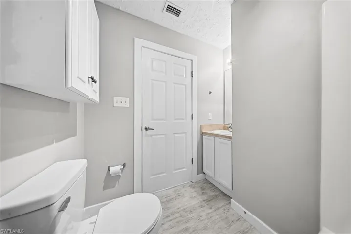 Half bathroom featuring a textured ceiling and vanity