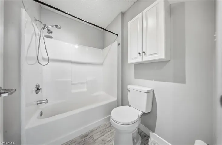 Bathroom featuring shower / washtub combination and a textured ceiling