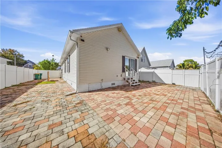 Rear view of house featuring a patio, crawl space, a fenced backyard, and entry steps
