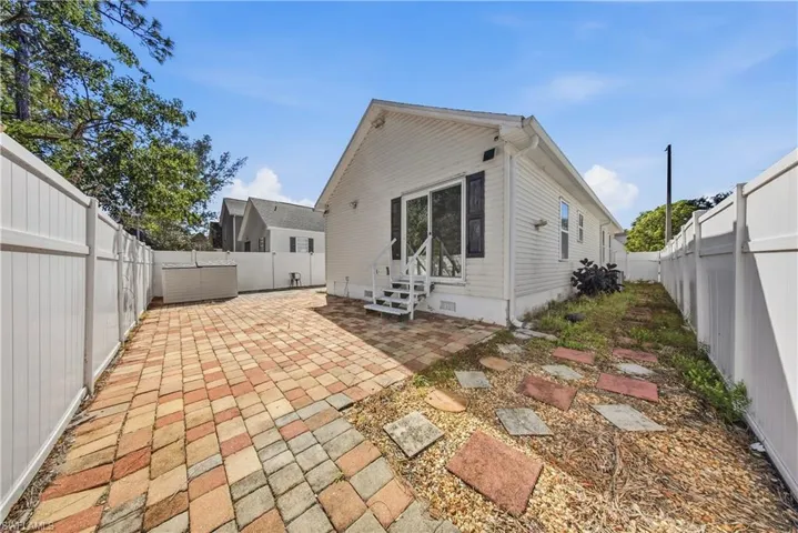 Rear view of property featuring a patio area, a fenced backyard, entry steps, and crawl space