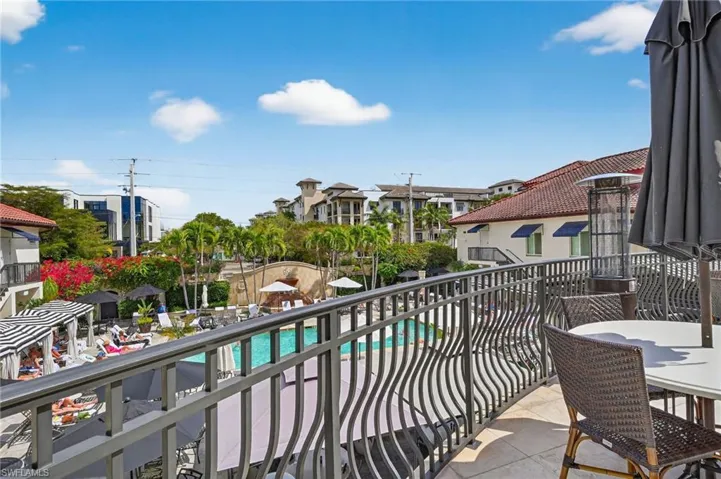 Balcony featuring view of pool area and outdoor dining space