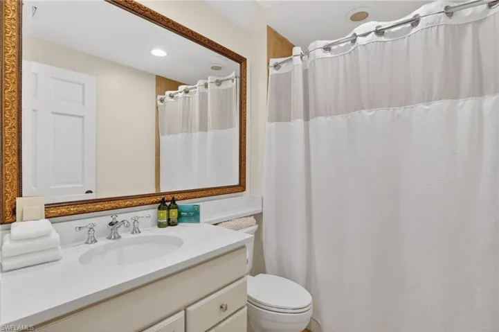 Full bath featuring vanity, curtained shower, and recessed lighting