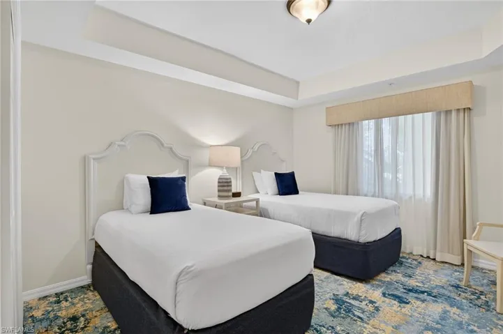 Bedroom with a raised ceiling and baseboards