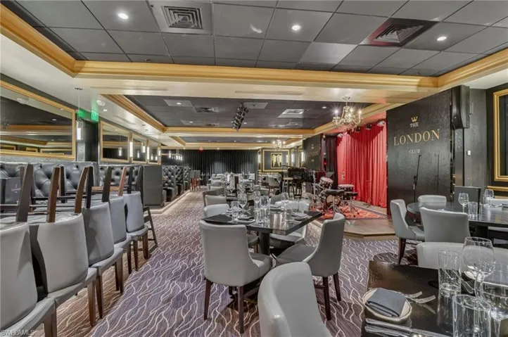 Dining area featuring dark carpet, a tray ceiling, and a drop ceiling