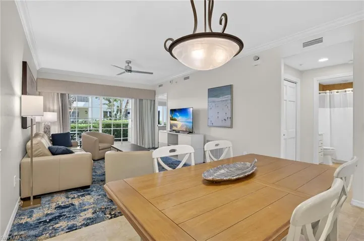 Dining space featuring ornamental molding, a ceiling fan, and light tile patterned flooring