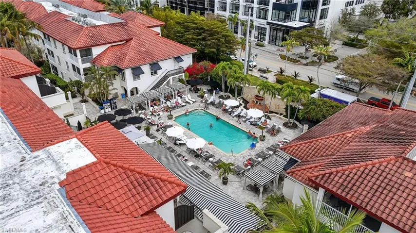 Drone / aerial view of a pool area and apartment complex / building