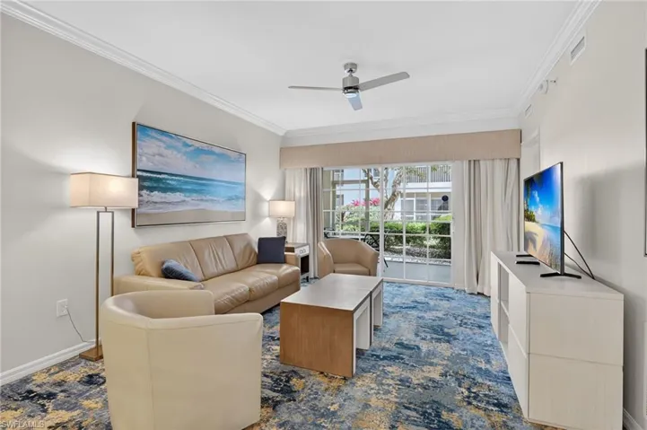Living room with ornamental molding and a ceiling fan