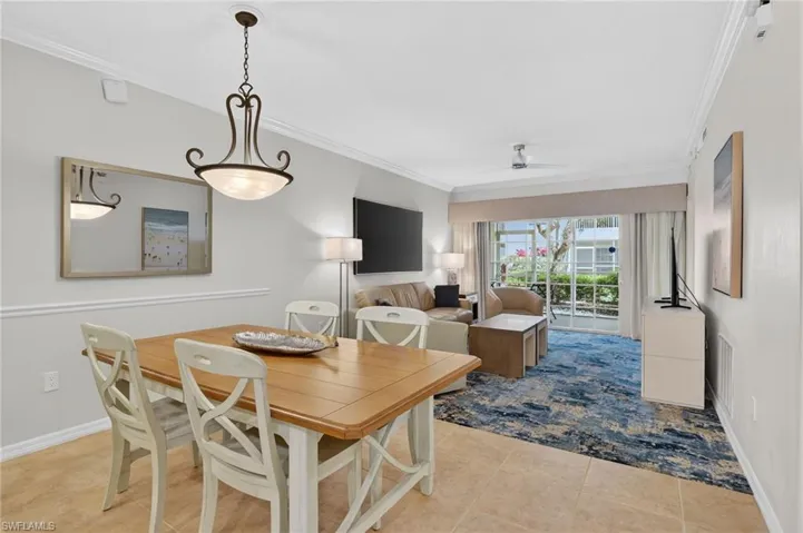 Dining area with crown molding, a ceiling fan, and light tile patterned floors