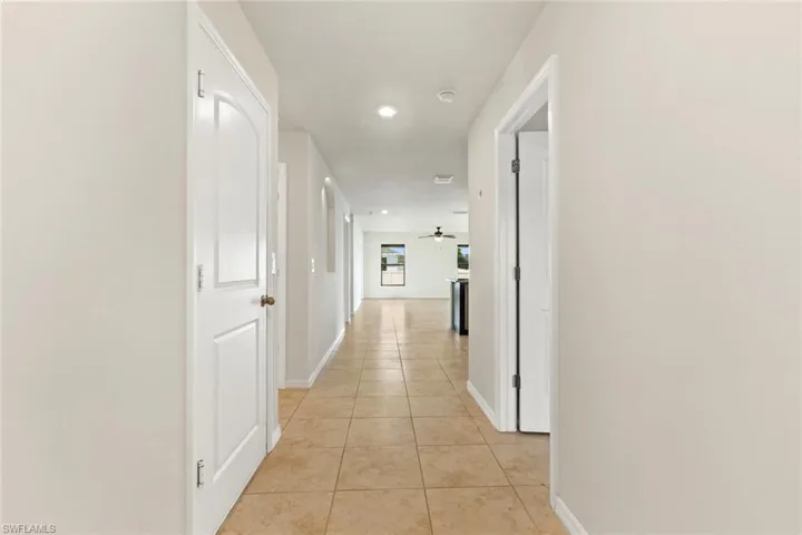 Corridor with light tile patterned floors and recessed lighting