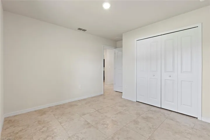 Unfurnished bedroom with a closet, light tile patterned floors, and recessed lighting