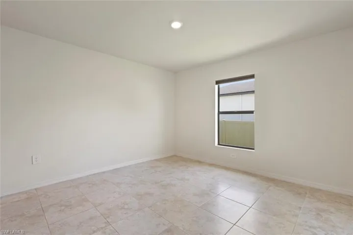 Empty room with light tile patterned floors and recessed lighting