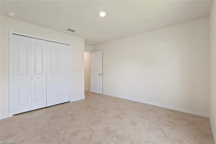 Unfurnished bedroom with recessed lighting, a closet, and light tile patterned flooring
